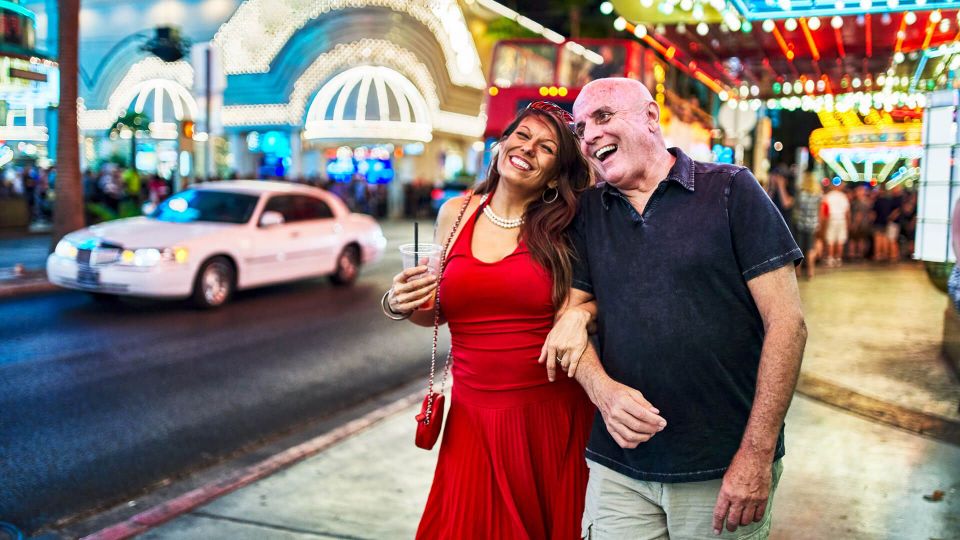 mature couple sightseeing in downtown las vegas streets at night.