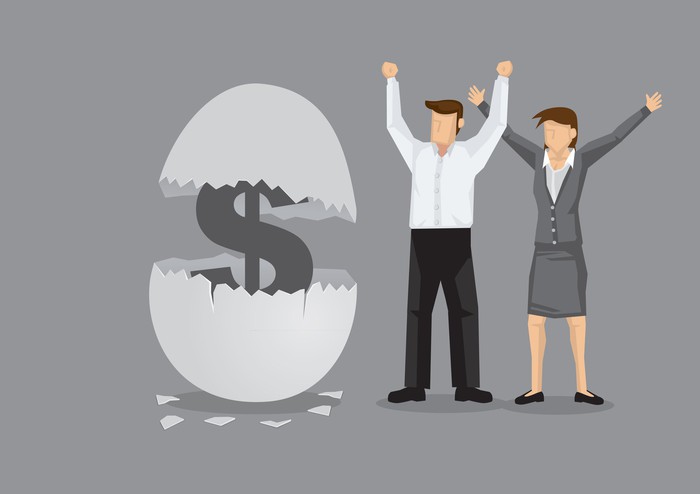 A cartoon man and woman stand next to a large egg that is hatching a dollar sign.