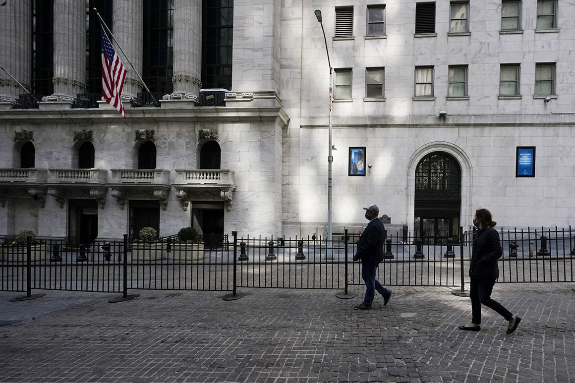 Pedestrians walk past the New York Stock Exchange.
