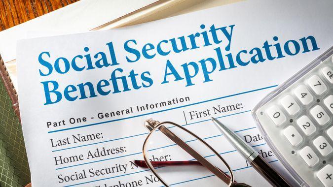 Social Security Benefits form with pen, glasses, and calculator