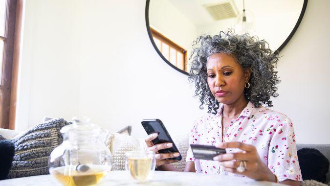 A black woman makes a purchase on her smartphone.